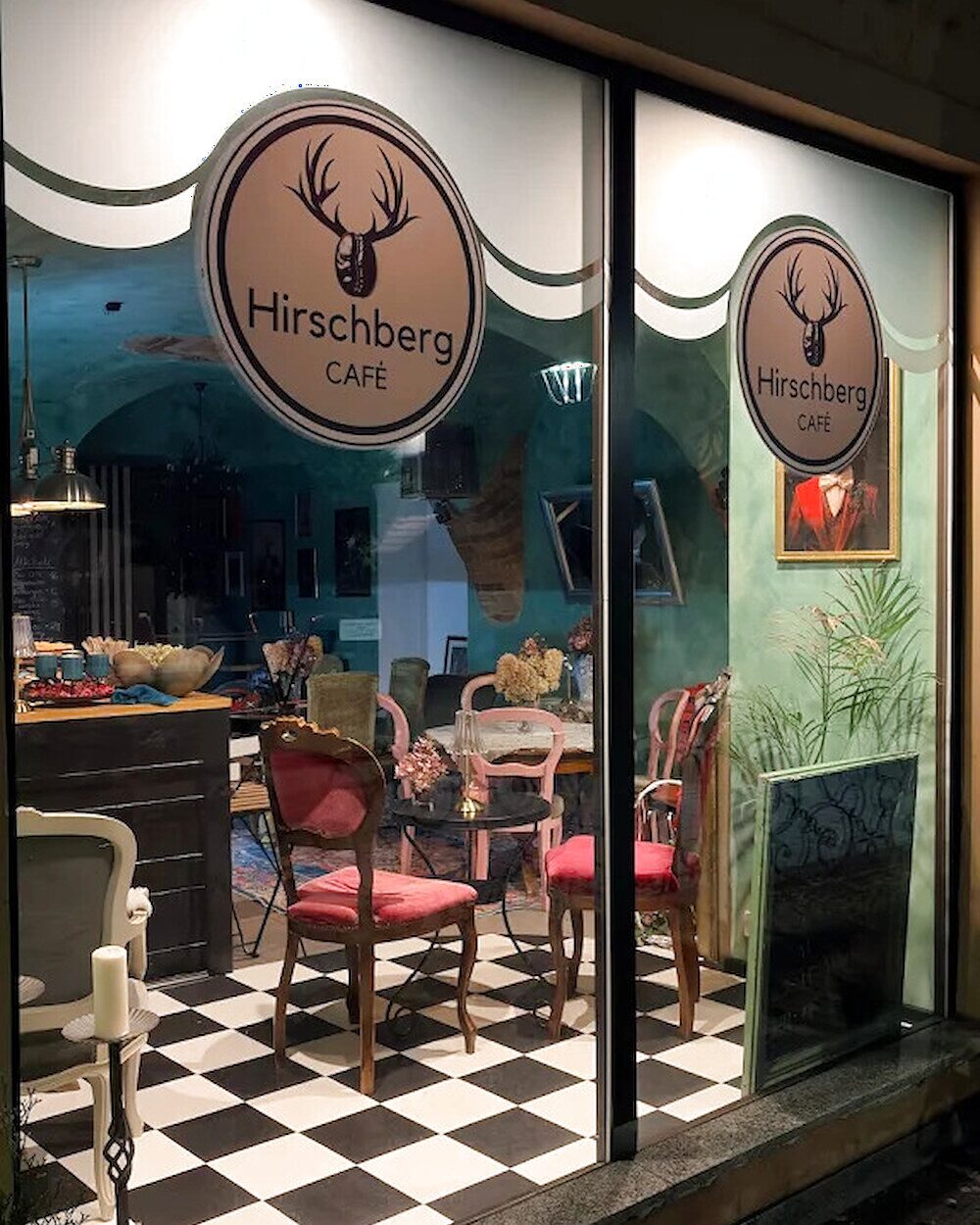 Witryna Café Hirschberg — szyld z jeleniem, szachownica na podłodze
